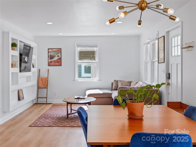 living room featuring recessed lighting, light wood-style flooring, baseboards, and an inviting chandelier