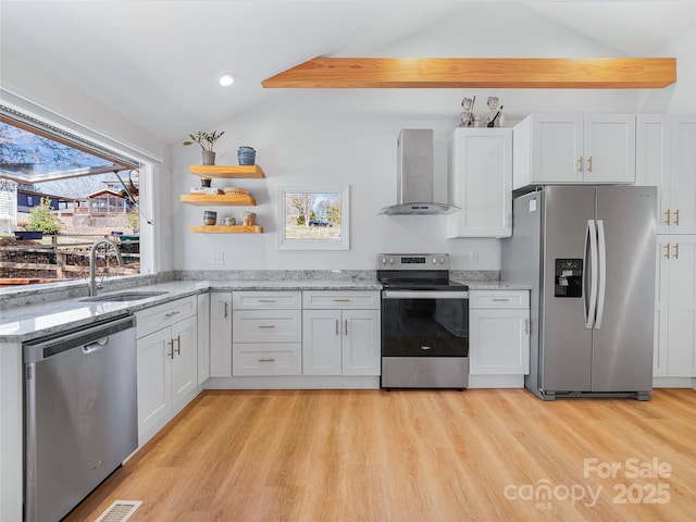 kitchen with a sink, open shelves, appliances with stainless steel finishes, wall chimney exhaust hood, and lofted ceiling