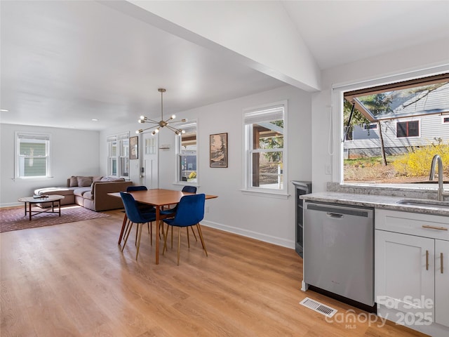 dining area featuring light wood-style flooring, visible vents, wine cooler, and a chandelier