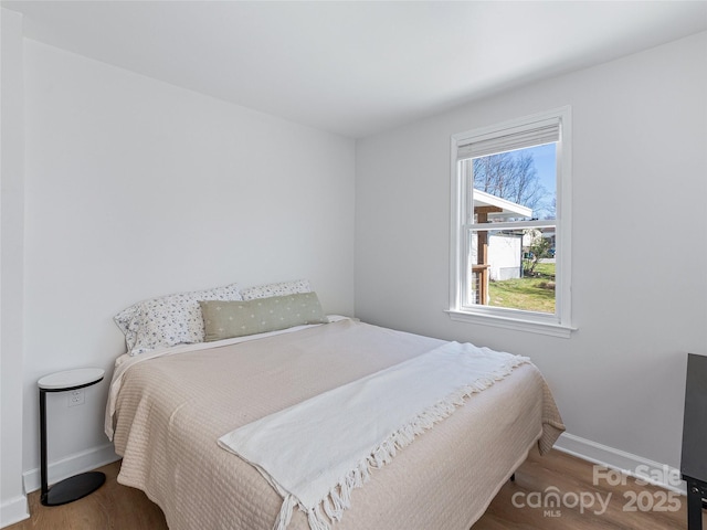 bedroom with wood finished floors and baseboards