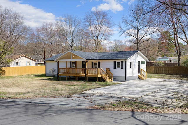 view of front of home featuring a shingled roof, a front yard, fence, and crawl space