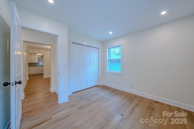 unfurnished bedroom with light wood-style floors, baseboards, and recessed lighting