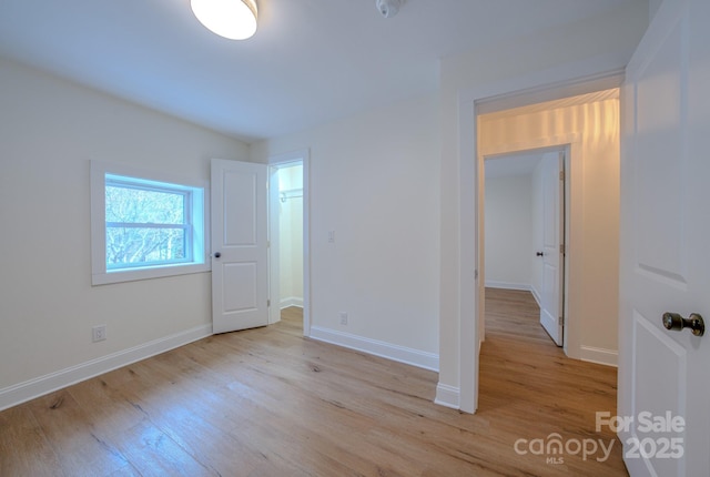 empty room with baseboards and wood finished floors