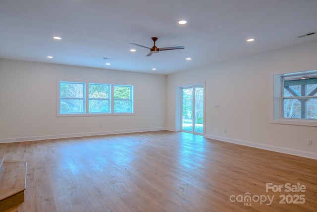 empty room featuring light wood-type flooring, baseboards, visible vents, and recessed lighting