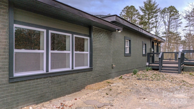 view of home's exterior with brick siding and a deck