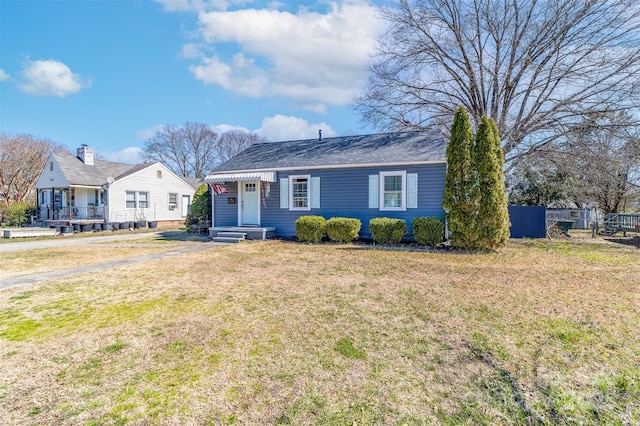 bungalow featuring a front lawn and fence