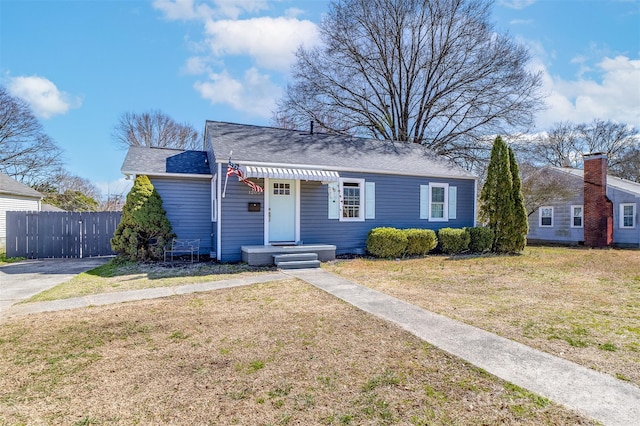 bungalow-style home with fence and a front yard