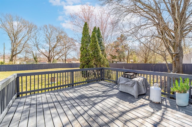 deck featuring a grill, a fenced backyard, and a yard