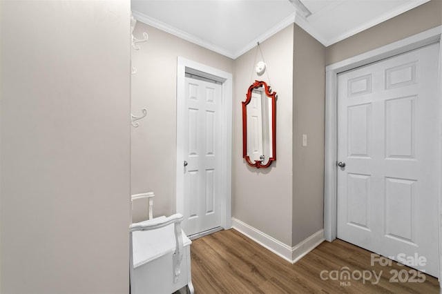 entryway featuring crown molding, baseboards, and wood finished floors