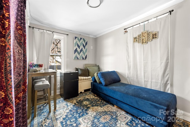 living area featuring crown molding and baseboards