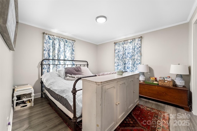 bedroom with baseboards, wood finished floors, and crown molding