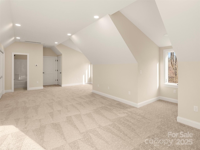 additional living space with light carpet, recessed lighting, lofted ceiling, and baseboards