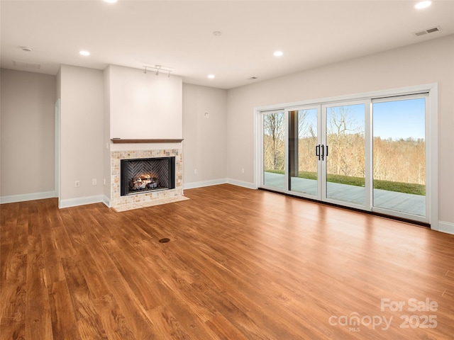 unfurnished living room with visible vents, recessed lighting, a fireplace, and wood finished floors