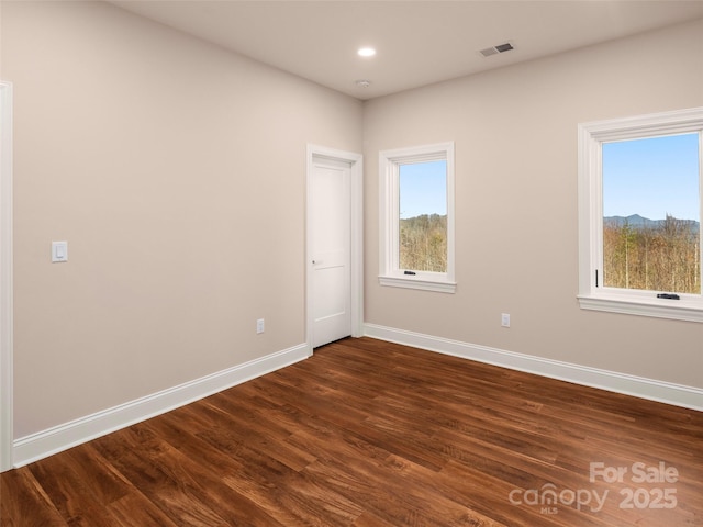 unfurnished room featuring recessed lighting, visible vents, baseboards, and dark wood-style floors