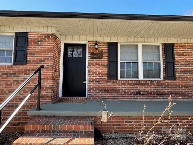 view of exterior entry featuring brick siding