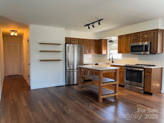 kitchen featuring backsplash, appliances with stainless steel finishes, dark wood-style floors, and light countertops