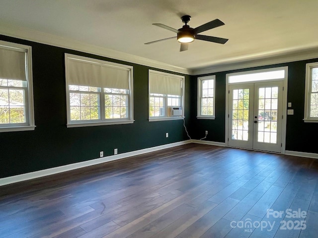 spare room with dark wood finished floors, crown molding, and a healthy amount of sunlight