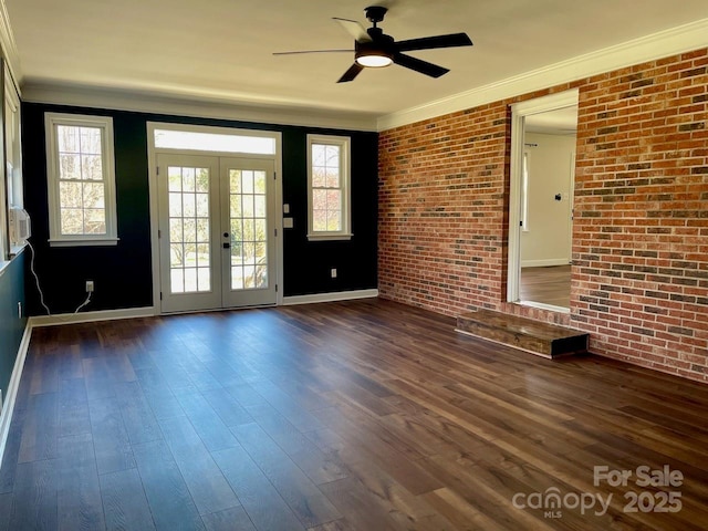 empty room featuring dark wood finished floors, brick wall, french doors, and ornamental molding