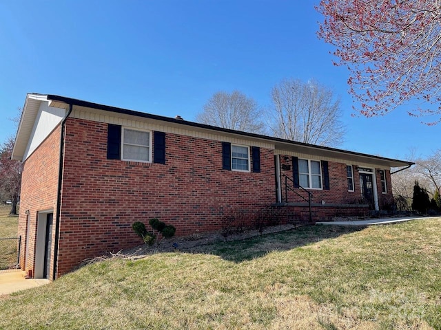 single story home featuring driveway, brick siding, an attached garage, and a front lawn