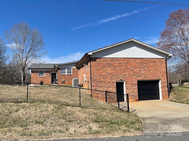 view of side of home featuring a garage, fence private yard, and brick siding