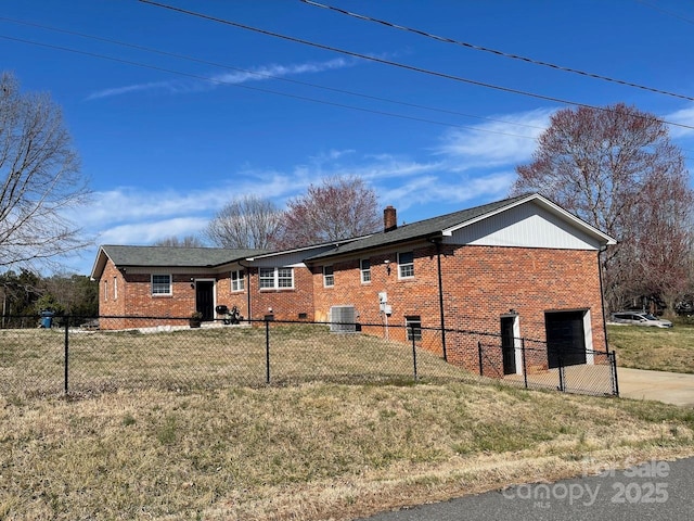 view of front facade featuring a fenced front yard, an attached garage, brick siding, and driveway