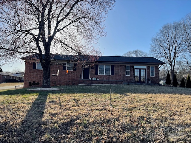 ranch-style home featuring brick siding, french doors, and a front lawn