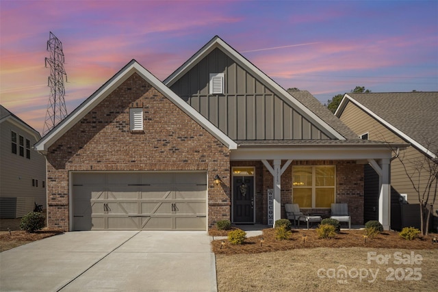 view of front facade with driveway, a porch, board and batten siding, a garage, and brick siding