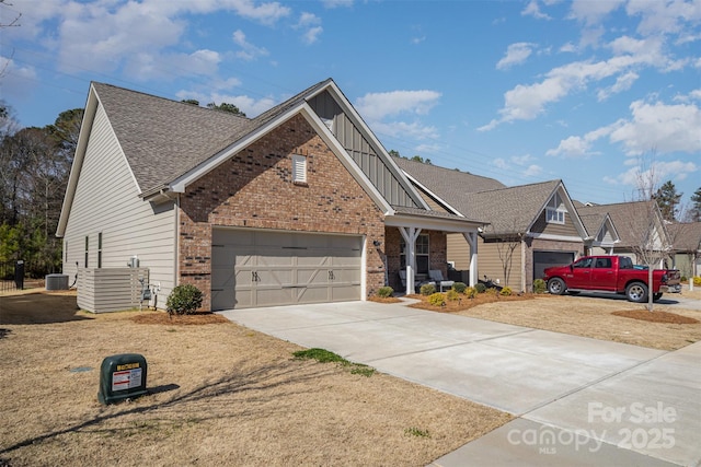 view of front of property with cooling unit, brick siding, concrete driveway, a garage, and board and batten siding