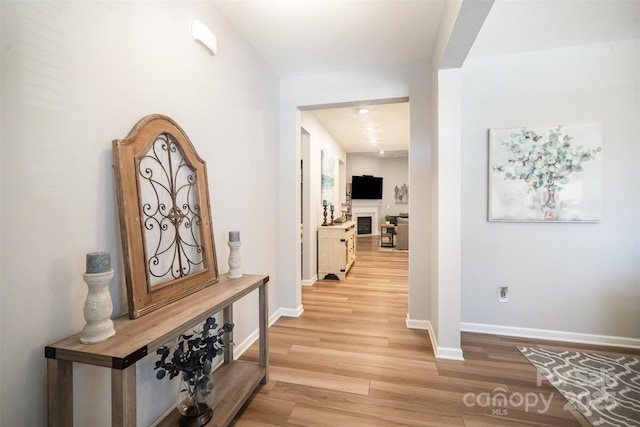 hallway featuring baseboards and light wood-style floors