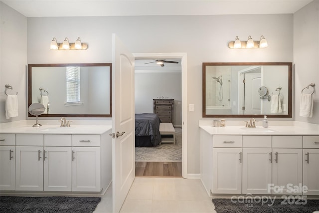 full bathroom with two vanities, a shower, and a sink