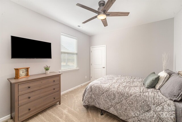 bedroom with ceiling fan, baseboards, visible vents, and light carpet