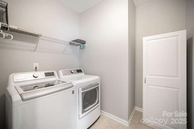 laundry room featuring light tile patterned floors, baseboards, independent washer and dryer, and laundry area