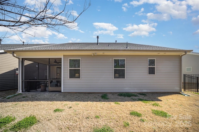 back of property with a yard, fence, and a sunroom