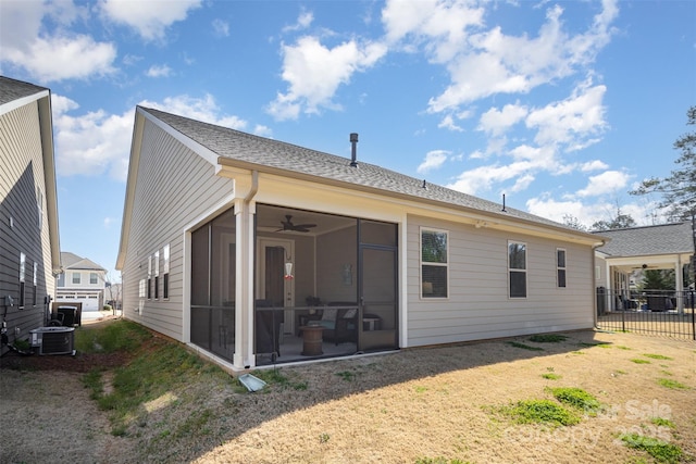 rear view of property with a ceiling fan, fence, a yard, central AC, and a sunroom