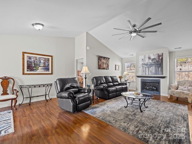 living area with visible vents, wood finished floors, a ceiling fan, and vaulted ceiling