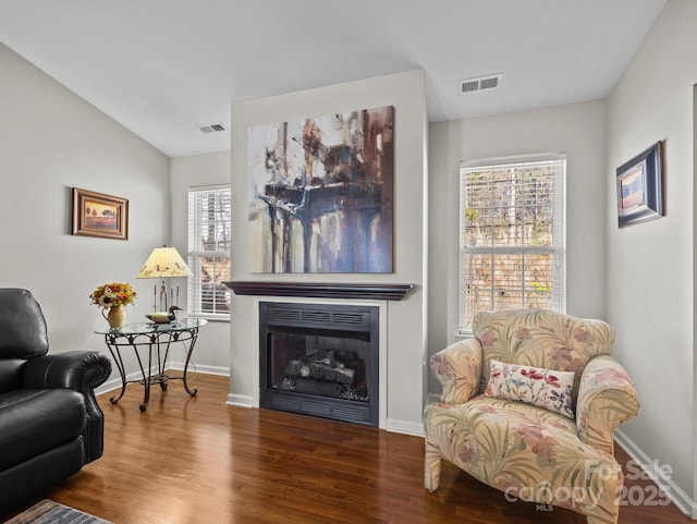 sitting room featuring visible vents, baseboards, wood finished floors, and a fireplace