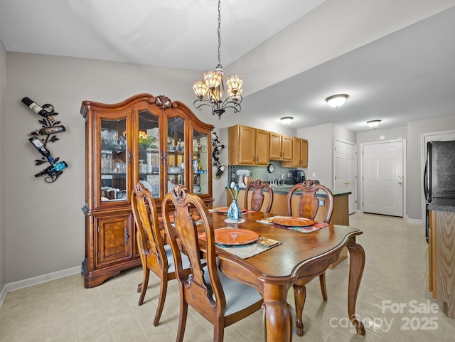 dining room with baseboards and a chandelier