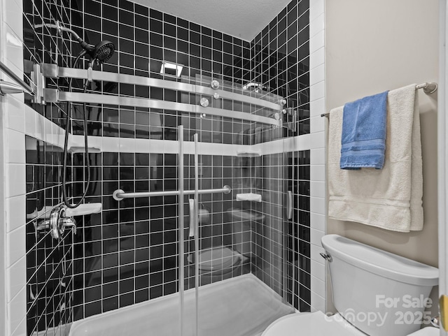 bathroom featuring a shower stall and toilet