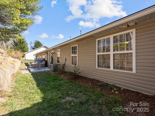 back of house with a yard and a patio