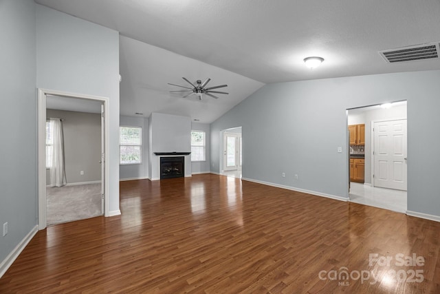 68 Wiltshire Cir, Fletcher, NC 28732 - unfurnished living room with wood finished floors, a ceiling fan, a fireplace, baseboards, and high vaulted ceiling