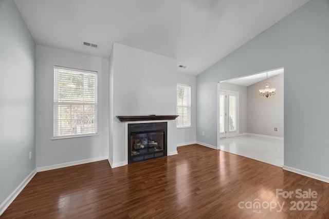 68 Wiltshire Cir, Fletcher, NC 28732 - unfurnished living room featuring a chandelier, plenty of natural light, wood finished floors, and vaulted ceiling