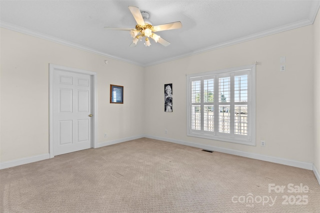 spare room featuring baseboards, visible vents, crown molding, and carpet flooring