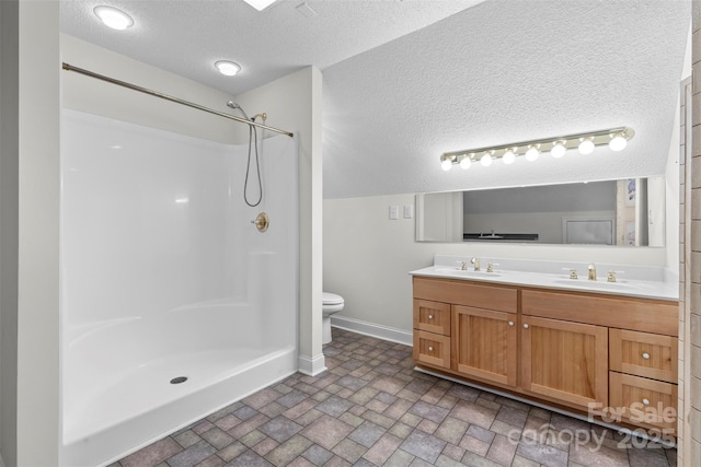 full bathroom featuring double vanity, baseboards, toilet, and a sink