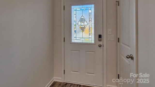 doorway with dark wood-style floors and baseboards