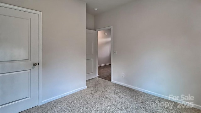 unfurnished bedroom featuring carpet floors and baseboards