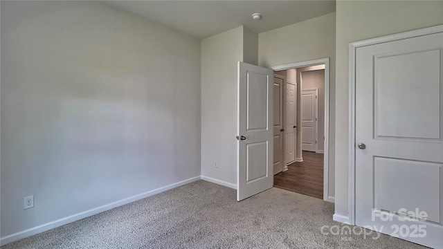 unfurnished bedroom with carpet flooring and baseboards