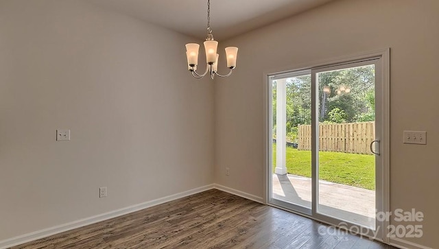 interior space with dark wood-style flooring, baseboards, and an inviting chandelier