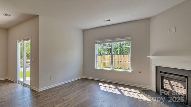 unfurnished living room with a healthy amount of sunlight, a fireplace, and visible vents