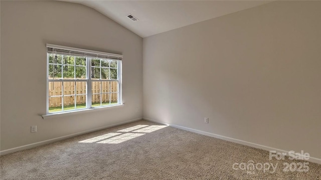 carpeted empty room with lofted ceiling, visible vents, and baseboards