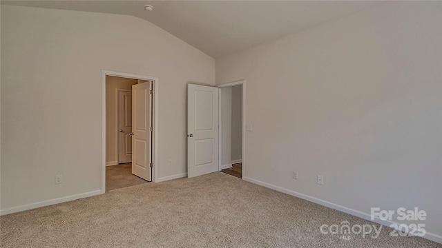 unfurnished bedroom featuring carpet floors, vaulted ceiling, and baseboards